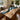 Custom poplar resin table featuring natural wood grain and a blue epoxy river design, creating a stunning wood dining table centerpiece in a bright modern dining space -BespokeTableCo