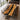 A large rectangular black walnut conference table with a glossy black resin river center, surrounded by wooden chairs with dark cushions in a modern room with large windows and natural light - BespokeTableCo