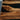 Custom black walnut epoxy resin table detail highlighting the contrast between walnut texture and transparent resin surface with premium dining table wood craftsmanship - BespokeTableCo