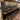 A custom Burl Cedar epoxy table used as a stylish bar counter, featuring dark resin inlays and natural wood grain in a modern home bar setting with stools and pendant lighting - BespokeTableCo