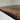 Custom epoxy resin black walnut dining table detail highlighting the edge wood table top and deep black epoxy table river details - BespokeTableCo