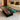 A handcrafted wooden coffee table made from golden camphor with a stunning resin inlay, styled in a contemporary living space beside a white sofa and soft rug - BespokeTableCo