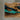 Close-up detail of a resin table showing the intricate turquoise, blue, and river patterns flowing through the golden camphor wood - BespokeTableCo