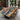 Olive wood epoxy dining table exhibited in a professional showroom, highlighting the straight edge, full glossy finish, and vivid blue resin river - BespokeTableCo