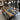 A wood dining table display featuring olive slab with blue resin inlay, showcased in a bright studio setting for interior design presentation - BespokeTableCo