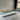 Exhibition view of a custom resin table with olive wood and flowing turquoise resin, displayed in a modern furniture gallery or design showroom - BespokeTableCo