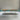 A wood dining table display featuring olive wood slab with bright turquoise resin inlay, showcased in a bright studio setting for interior design presentation - BespokeTableCo