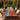 Custom epoxy resin walnut dining table with a blue resin river design placed in an outdoor patio dining area surrounded by greenery and natural scenery - walnut dining table and resin table - BespokeTableCo