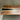 Close-up detail of an epoxy resin table countertop showing the dark black resin center stripe flowing through the rich walnut grain - BespokeTableCo