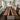 A large rectangular kitchen island with a white base and a thick live-edge walnut countertop featuring a dark black resin center stripe between rich brown wood grain, shown in a bright modern kitchen with natural light - BespokeTableCo