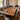 A luxury black walnut epoxy resin dining table with a unique wood dining table top design, surrounded by dining chairs in a warm modern home interior - BeSpokeTableCo