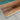 Close-up detail of black walnut wood top table countertop showing the smooth epoxy resin river, natural wood grain, and handcrafted polished finish - BespokeTableCo