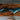 Close-up workshop view of a walnut slab with turquoise resin river being sanded and finished, emphasizing the detail and care put into every solid wood dining table top - BespokeTableCo